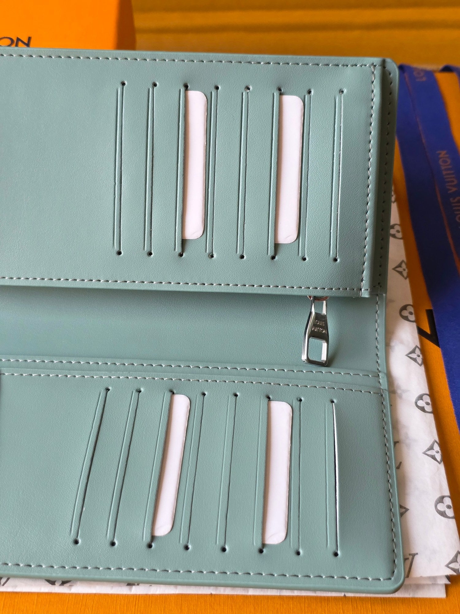 Light blue leather small bag open with rows of slots and snap button closure