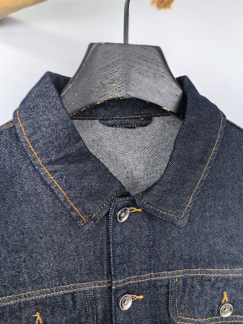 Moncler dark denim jacket close-up of pointed collar and buttoned front placket