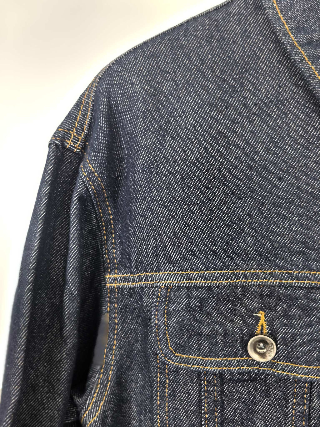 Moncler dark denim jacket close-up of shoulder seam and chest flap pocket