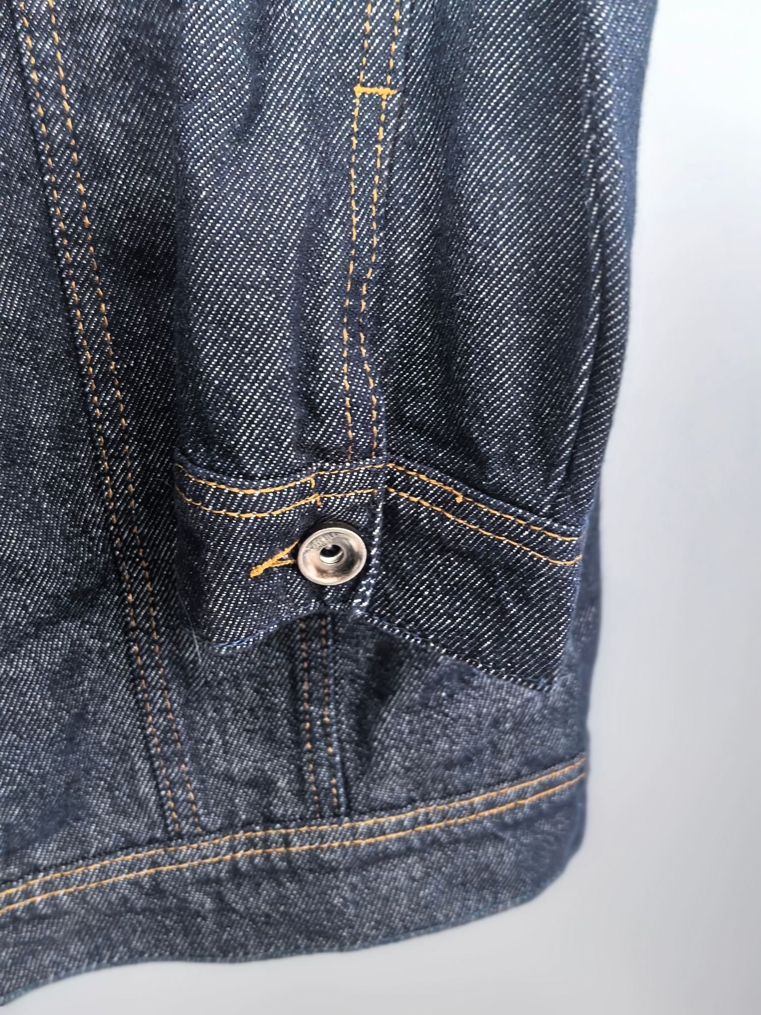 Moncler dark denim jacket sleeve hem close-up with buttoned pocket detail