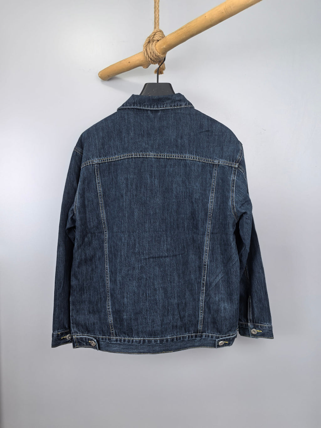 Blue denim jacket back view with buttoned placket and ribbed hem detail