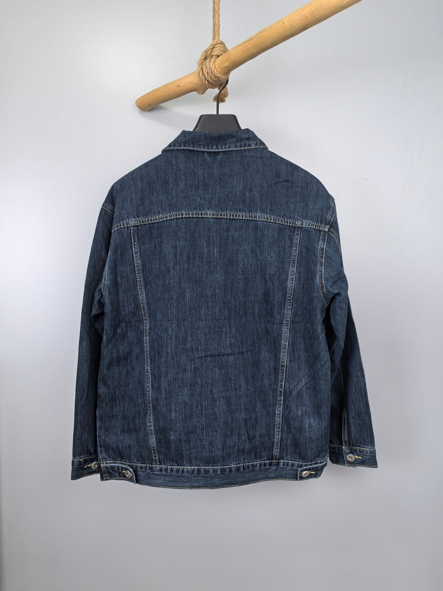 Blue denim jacket back view with buttoned placket and ribbed hem detail