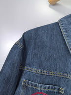 Blue denim jacket shoulder and chest pocket close-up with contrast stitching