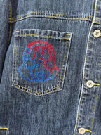 Blue denim jacket chest pocket with embroidered multicolor graphic patch