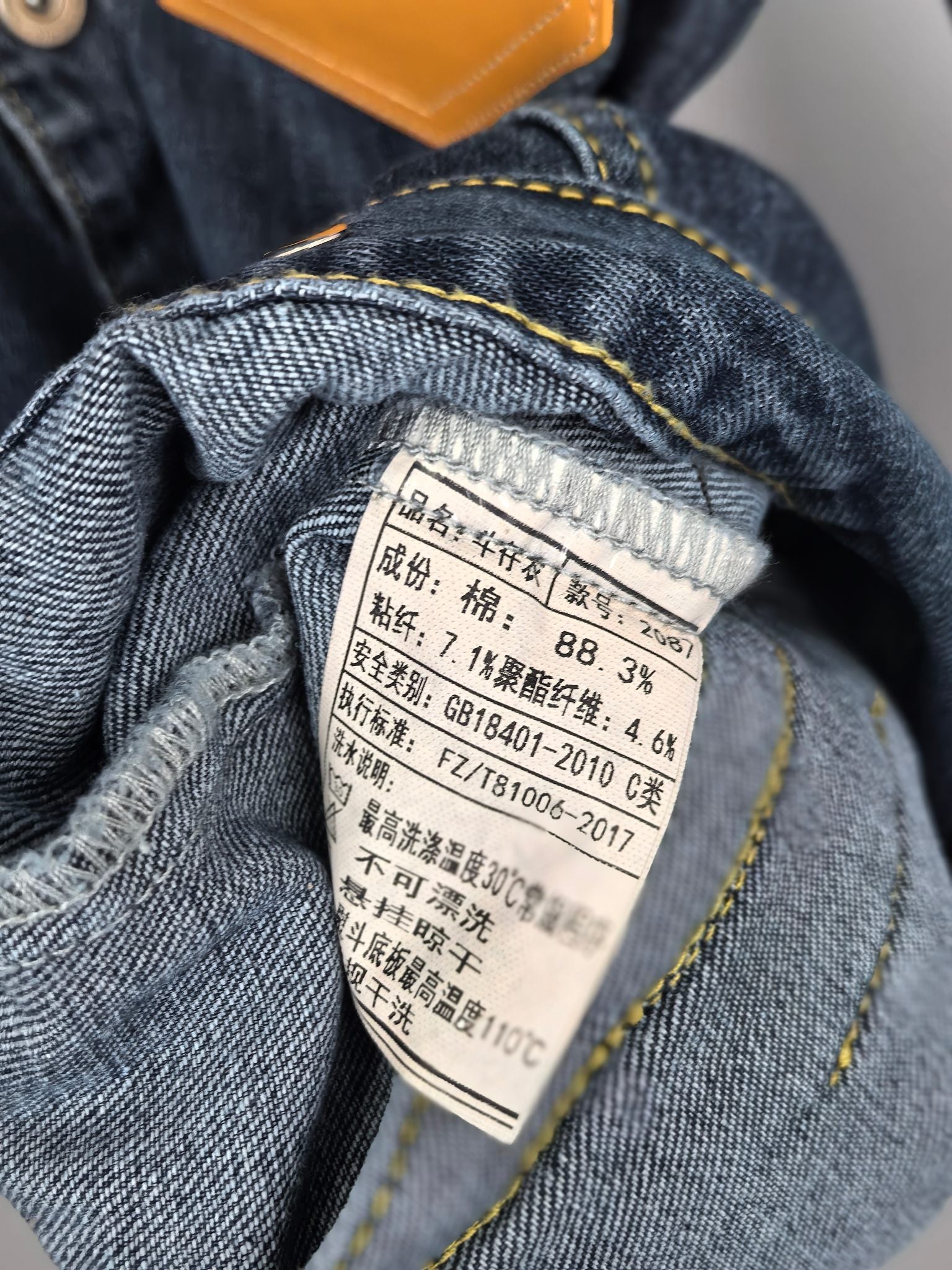 Blue denim jacket interior care label with fabric composition percentages