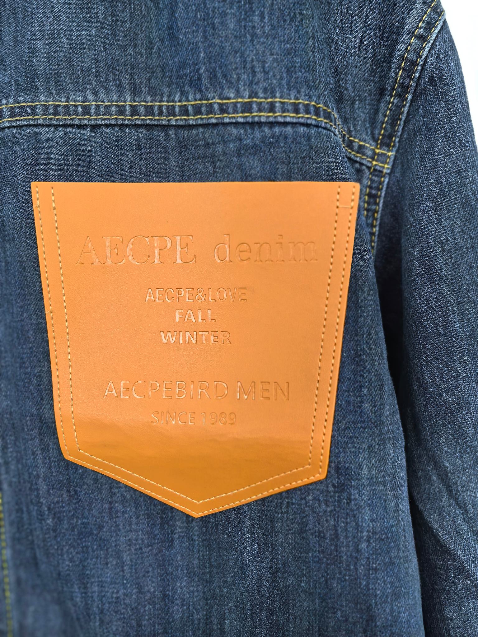 Blue denim jacket sleeve pocket patch with orange leather-like label
