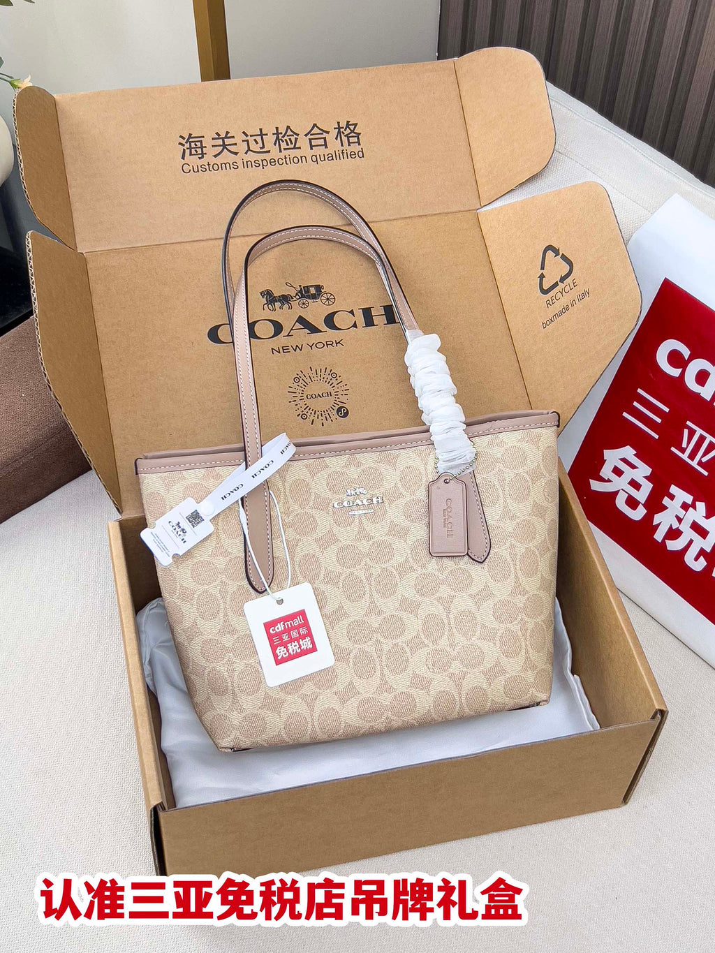 Beige COACH monogram tote bag with long handles in a retail gift box