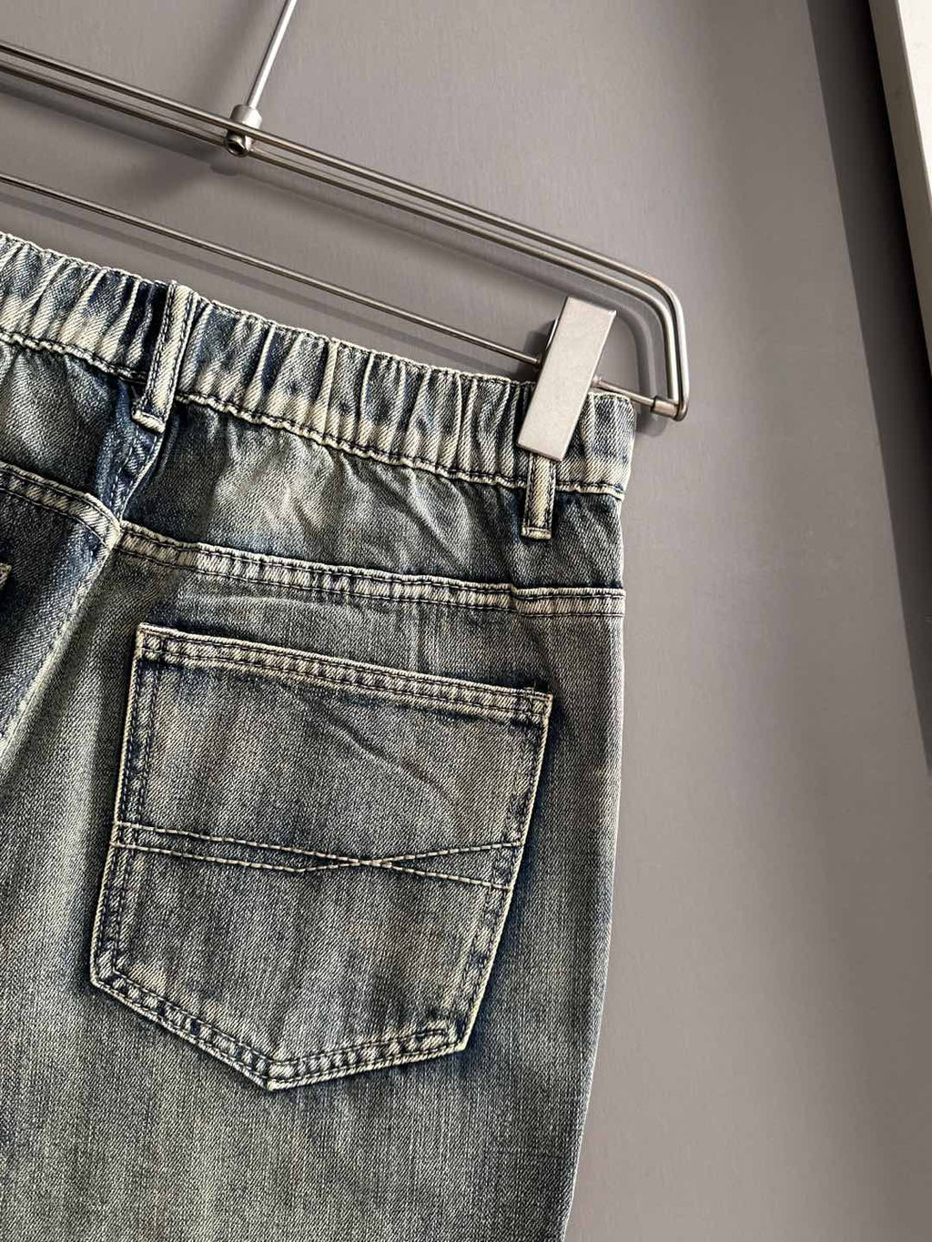 Denim pants back/side pocket close-up with belt loops and stitched patch pocket