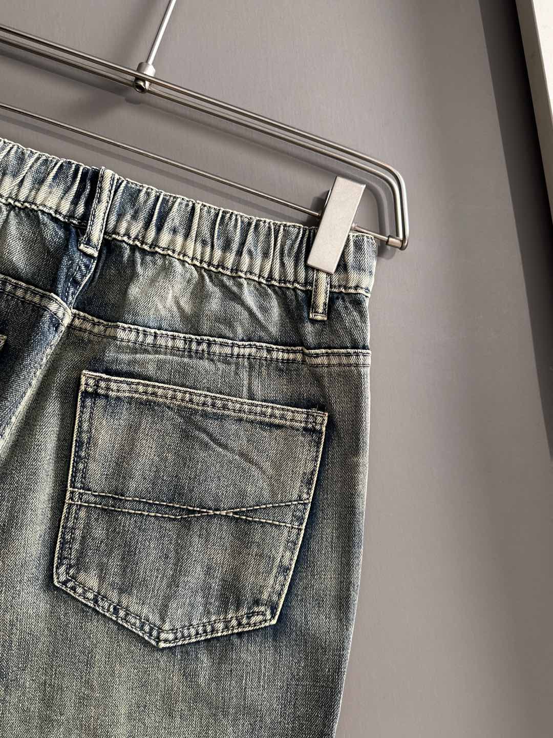 Denim pants back/side pocket close-up with belt loops and stitched patch pocket