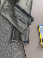 Cuffed hem detail on light wash denim pants with stitched pocket seams