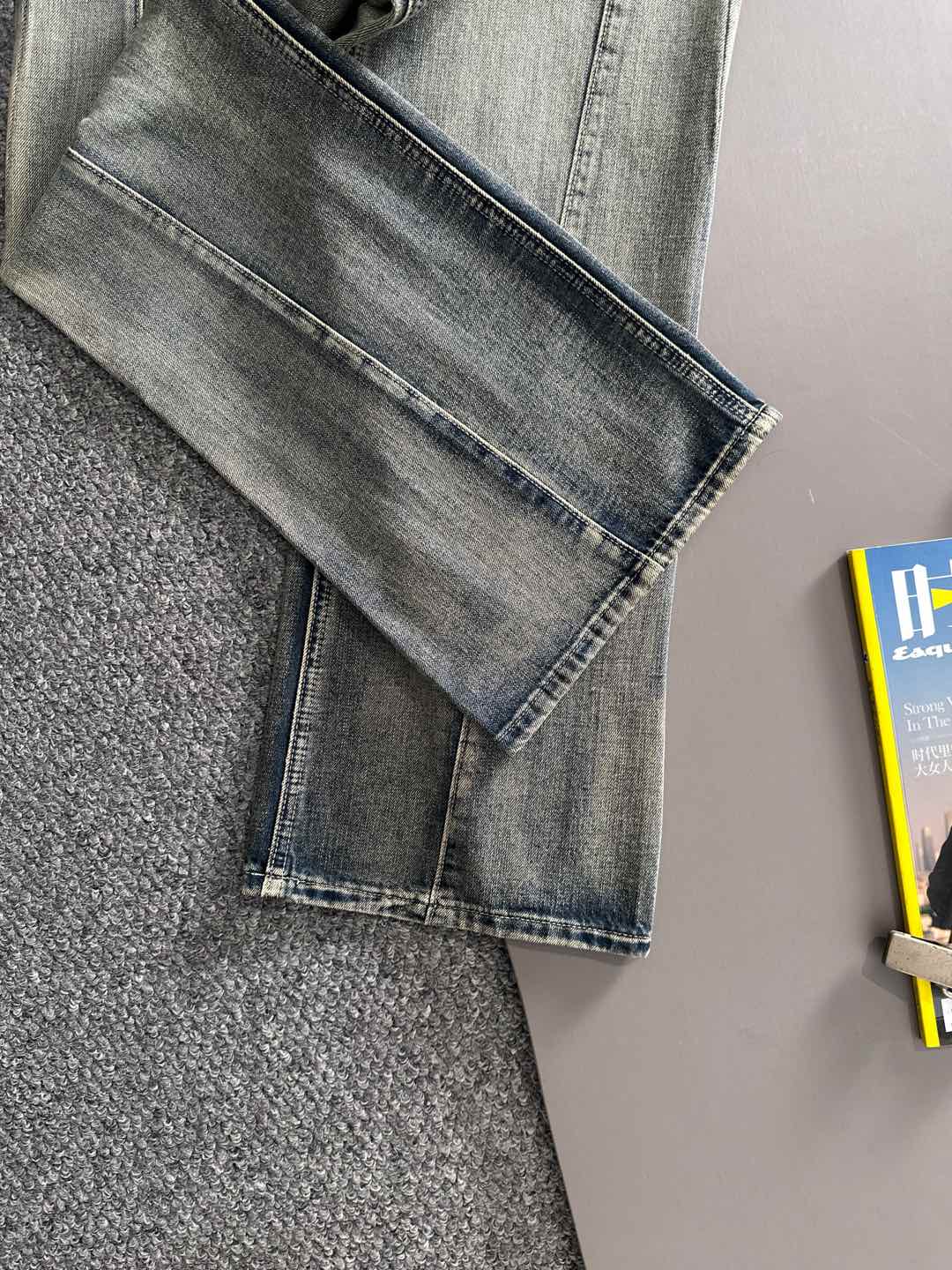 Cuffed hem detail on light wash denim pants with stitched pocket seams