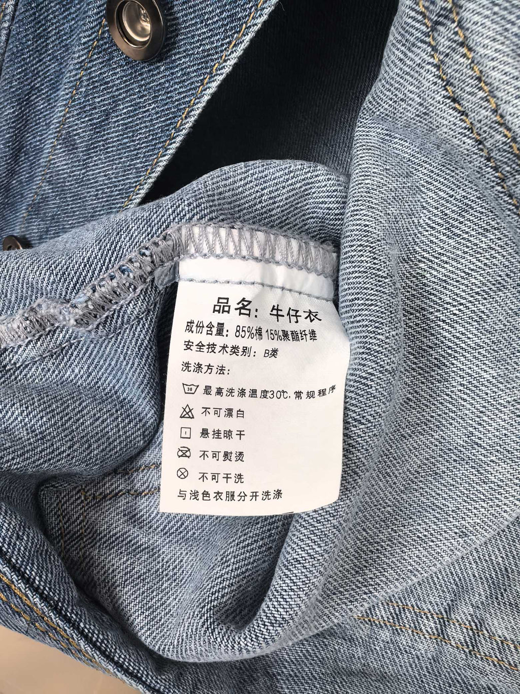 Burberry denim vest interior neck label with care information on blue fabric