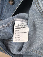 Burberry denim vest interior neck label with care information on blue fabric