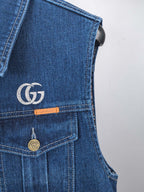 Gucci blue denim vest detail with GG logo patch, button closure, and chest pocket