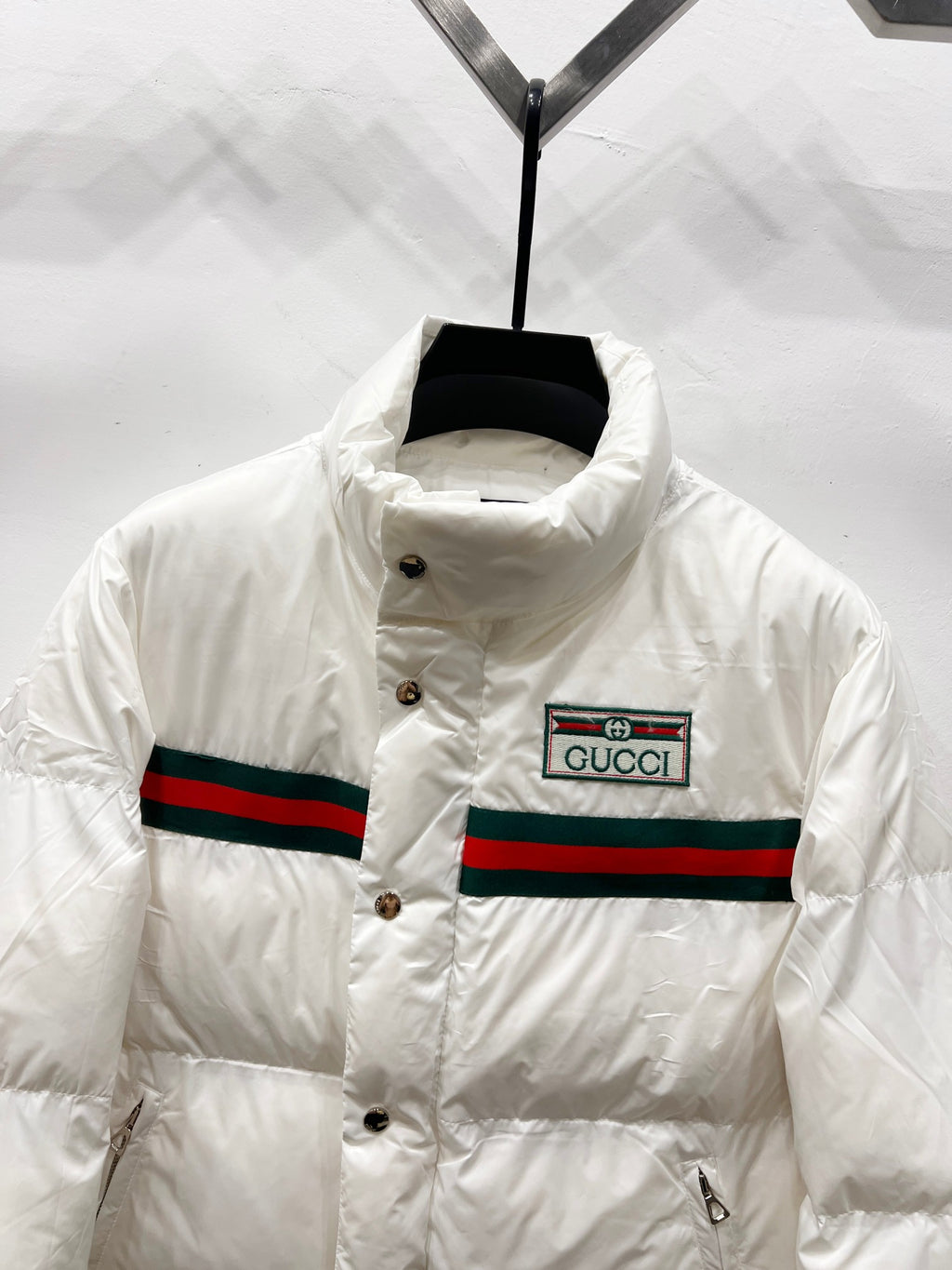 Gucci white puffer jacket front with button placket and striped band logo patch