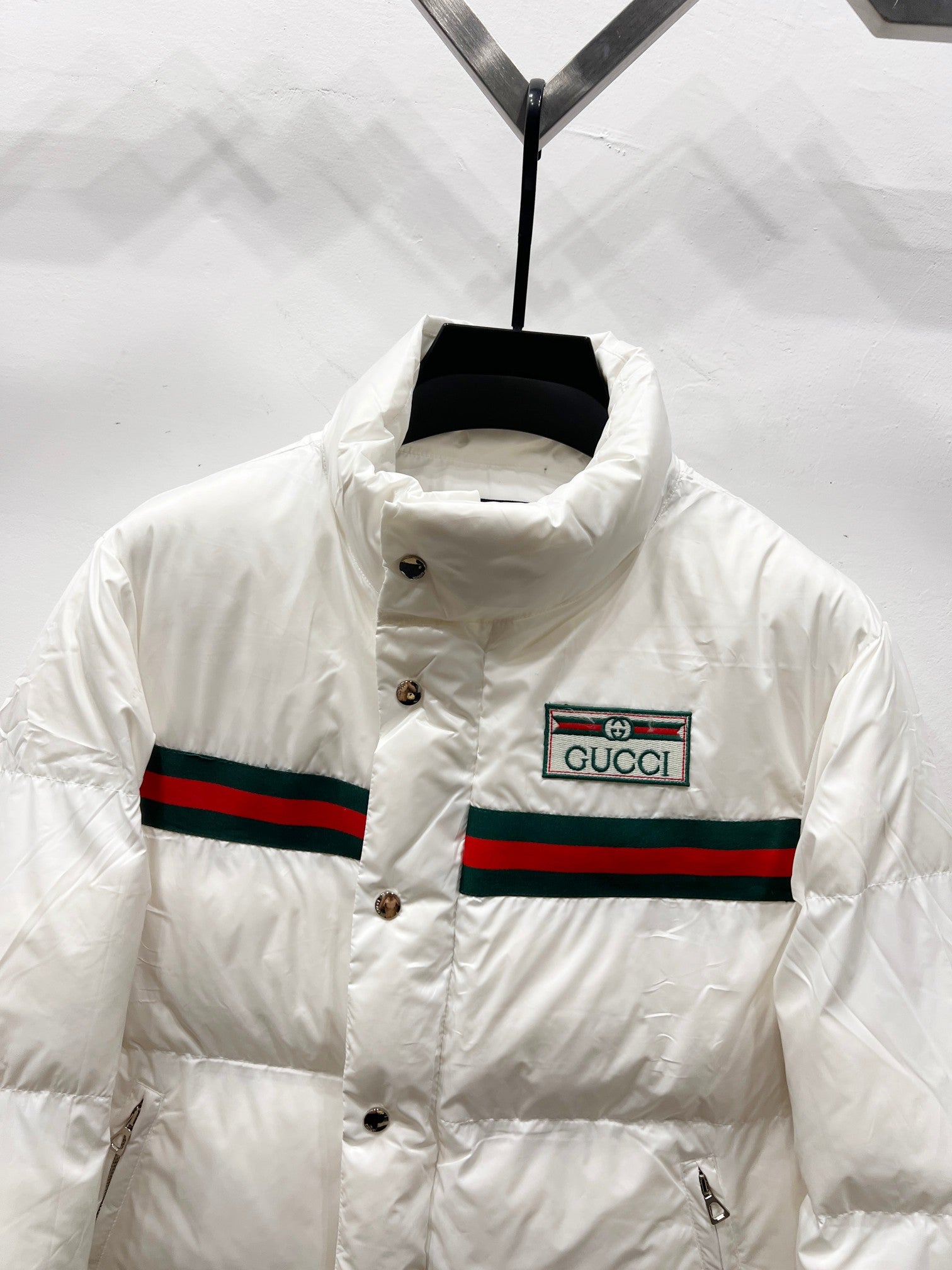 Gucci white puffer jacket front with button placket and striped band logo patch