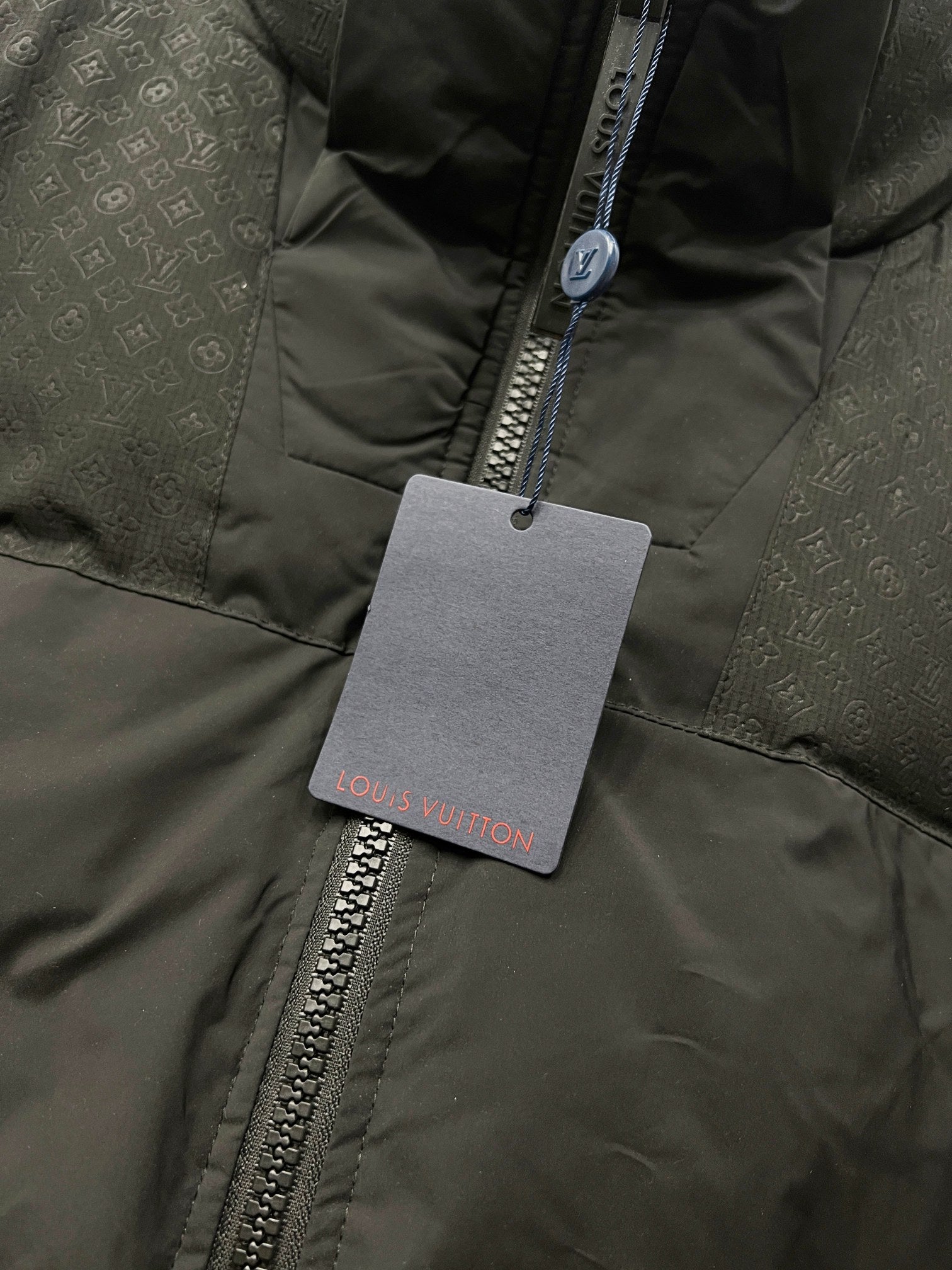 Puffer jacket front with zipper and hanging Louis Vuitton tag