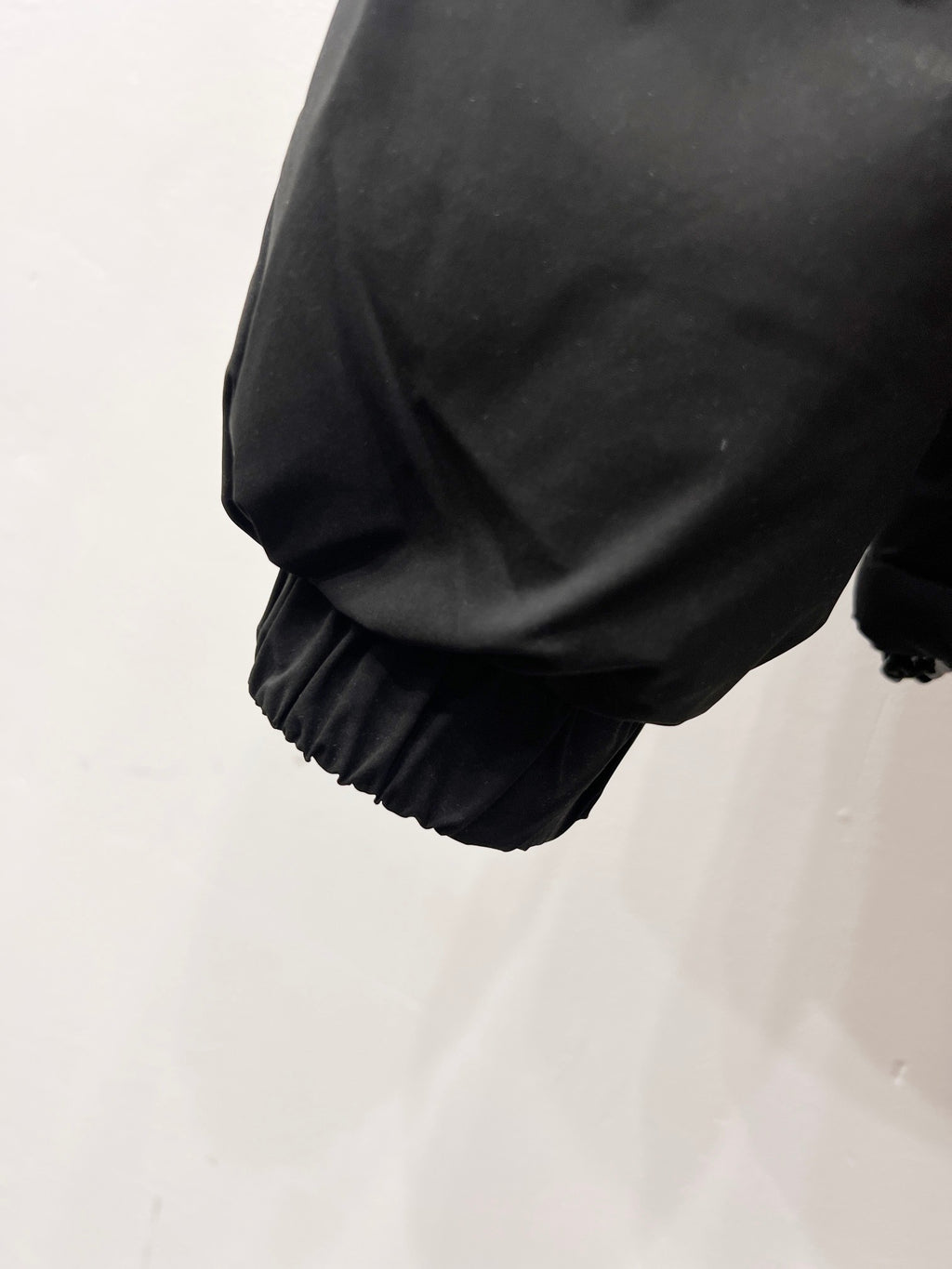 Puffer jacket sleeve cuff with elastic hem in dark gray
