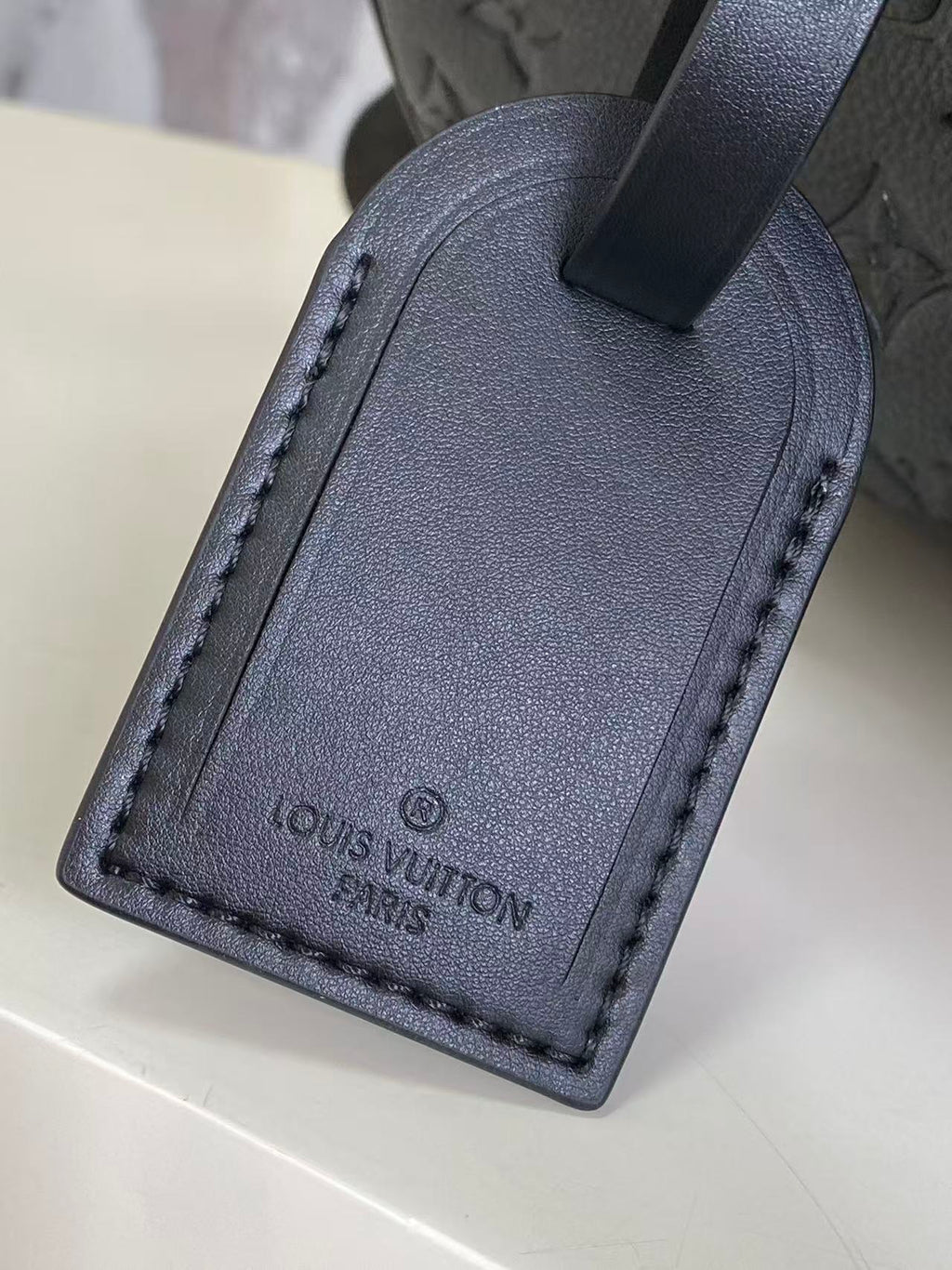 Louis Vuitton leather luggage tag, dark navy with stitched edge and logo