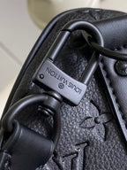 Louis Vuitton handle clasp on dark navy monogram bag, metal hardware close-up