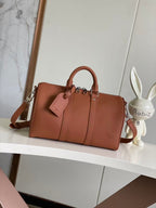 Brown leather structured handbag with top handles and crossbody strap, zipper front panels