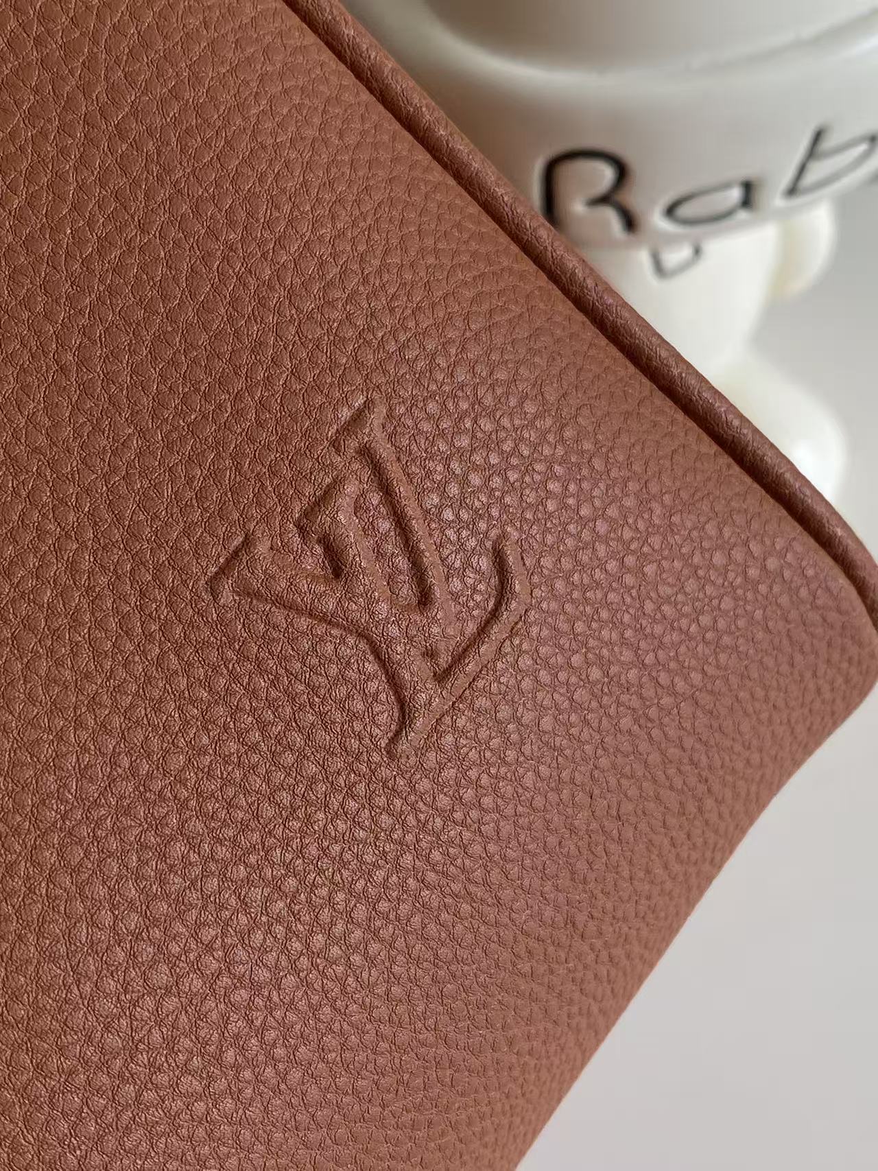 Brown textured leather with embossed Louis Vuitton-style logo detail