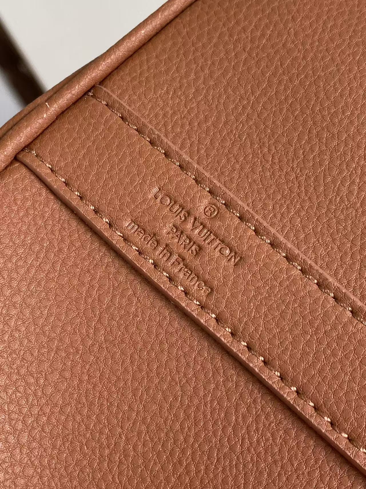 Brown leather handbag with stitched inner pocket label strip