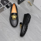 Versace black leather loafers with gold emblem and visible side sole tread