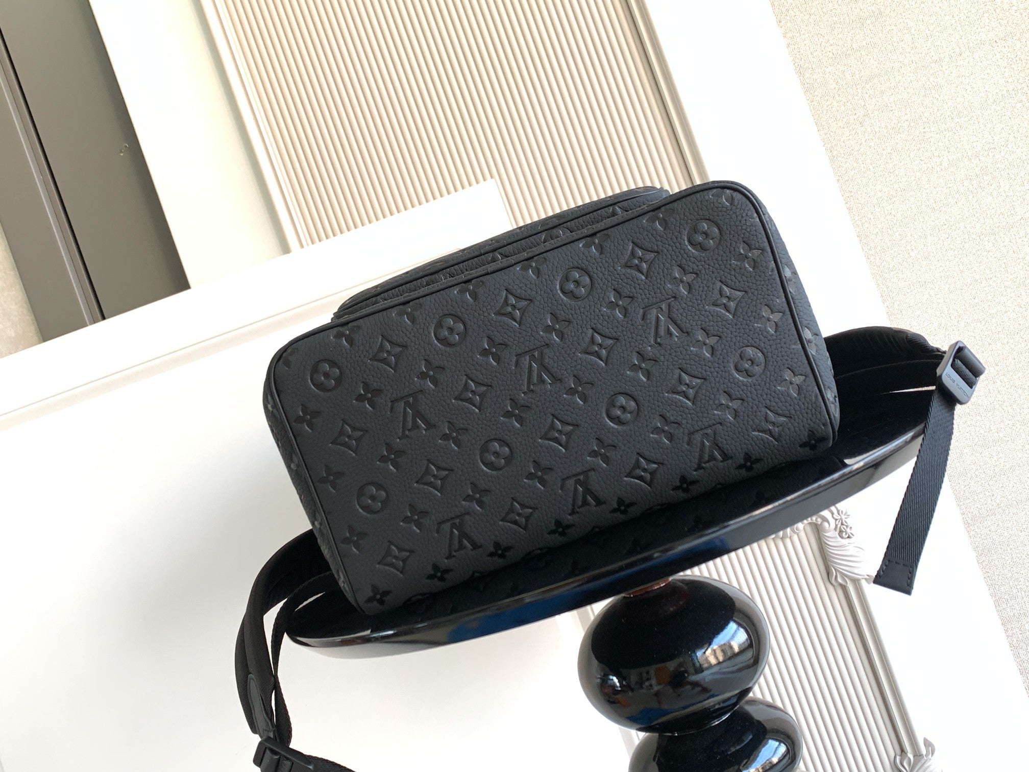 Louis Vuitton monogram backpack top flap close-up in dark gray with leather edge trim