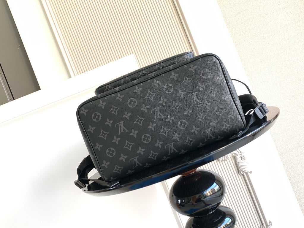 Monogram backpack angled view with front flap pocket and adjustable straps; dark