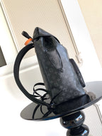 Monogram backpack with adjustable shoulder straps and side pocket; dark finish