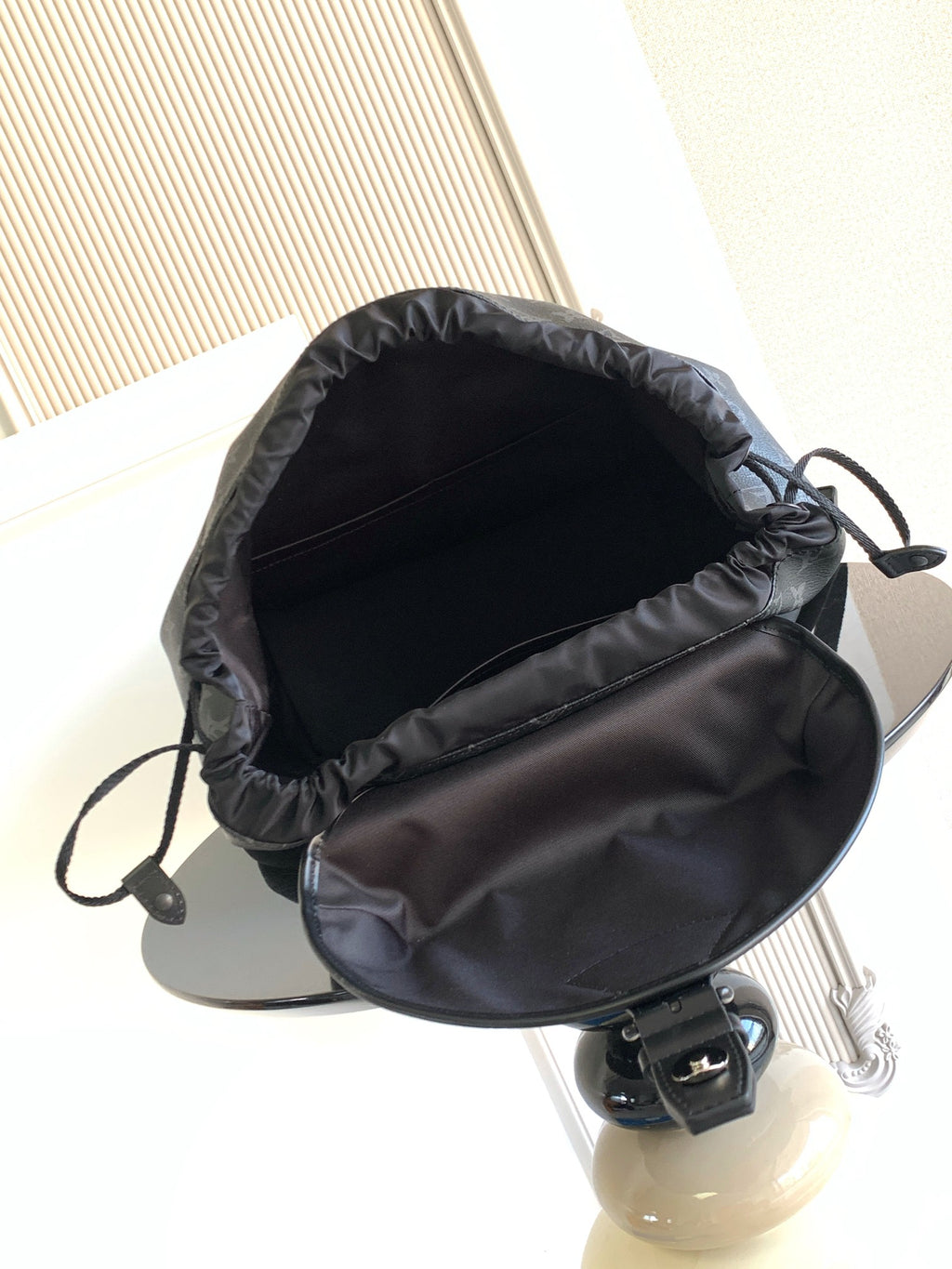 Monogram backpack interior with drawstring opening and black fabric lining