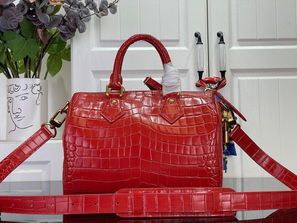 Louis Vuitton red structured tote bag with top handles, gold hardware, and long strap