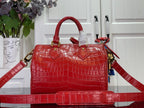 Louis Vuitton red structured tote bag with top handles, gold hardware, and long strap