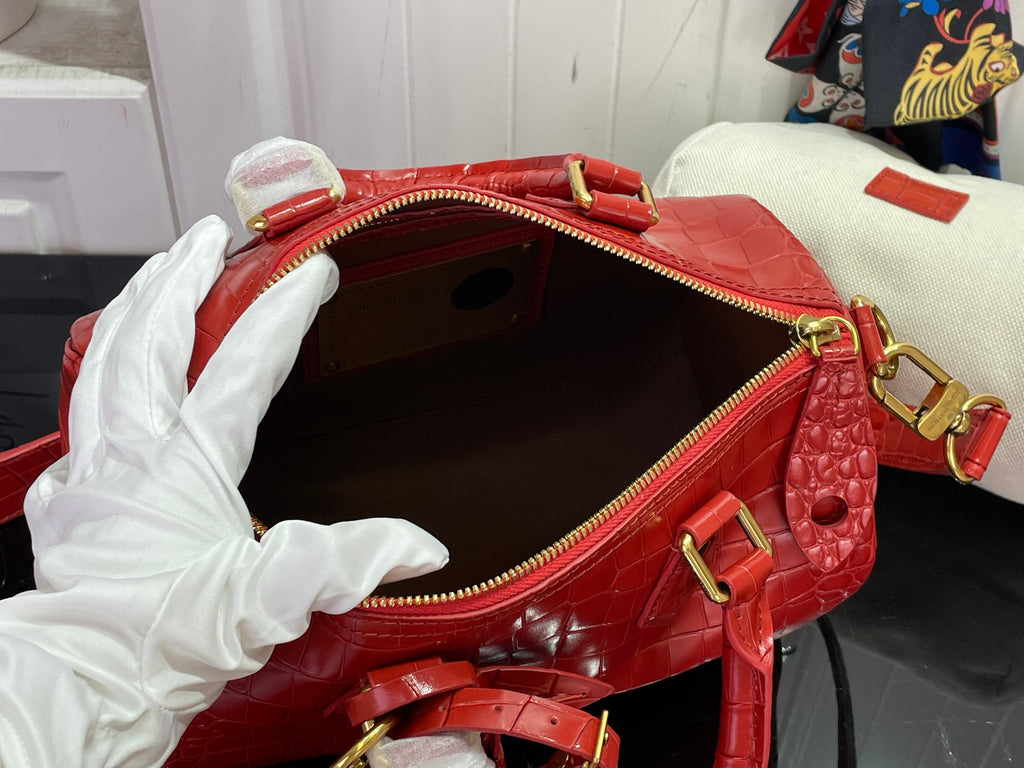 Louis Vuitton red bag interior with zip opening, gold pull, and side strap hardware