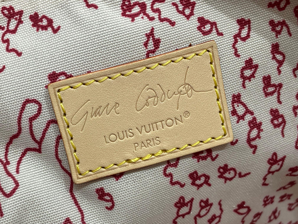 Louis Vuitton leather logo patch with gold stitching on light fabric background
