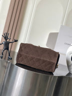 Chanel clutch-style bag in dark brown fabric with quilted texture and top flap