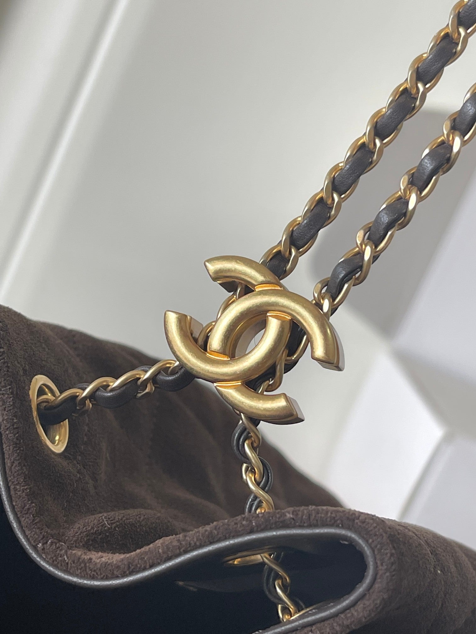 Chanel bag chain strap close-up with gold turn-lock clasp and leather edge