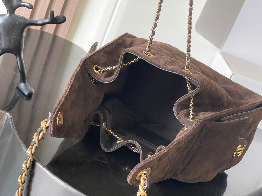 Chanel bag open top with interior lining, gold chain straps, and front logo detail
