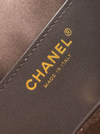 Chanel logo patch on dark brown leather with gold lettering and stitched edge