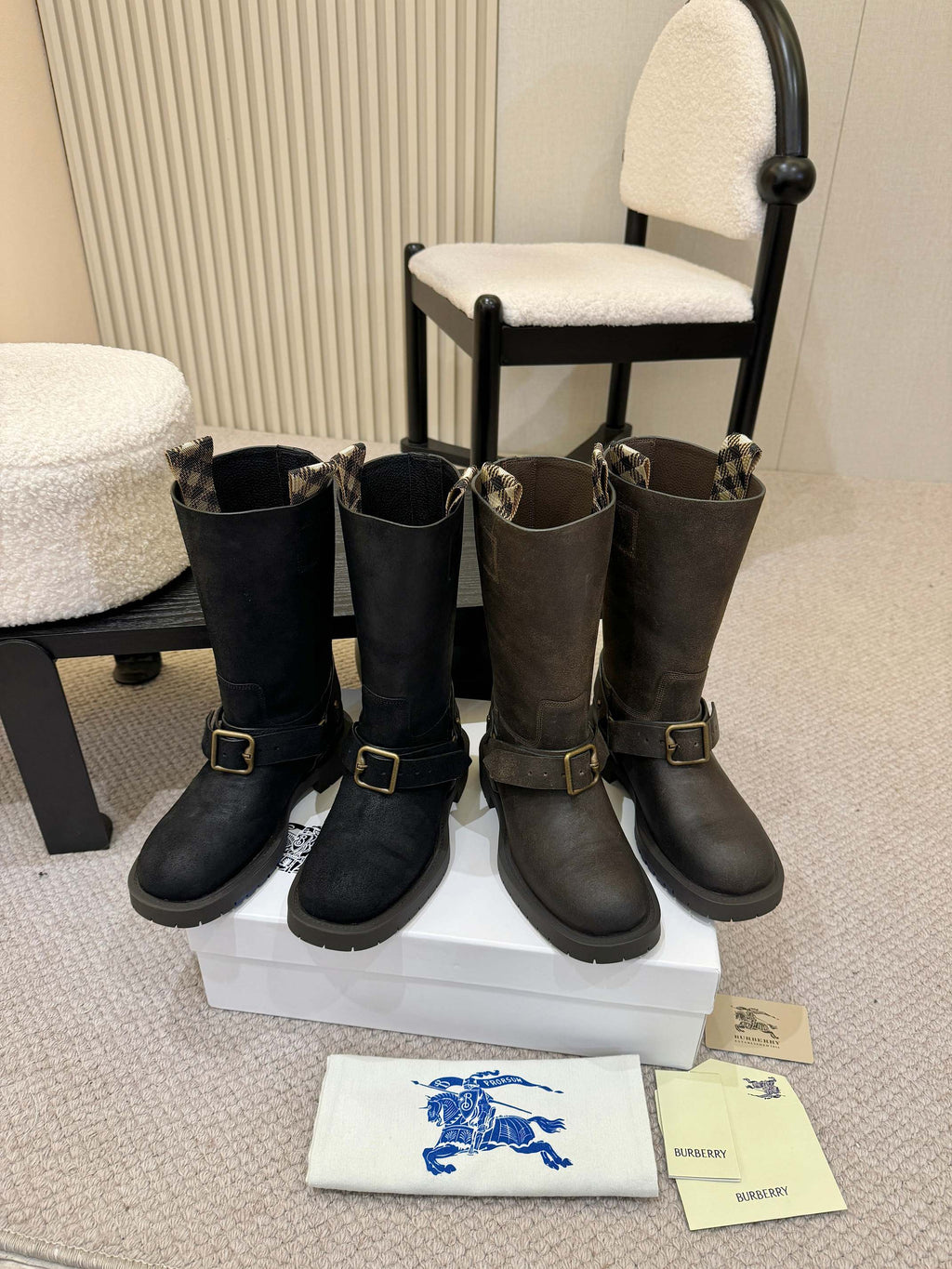 Black mid-calf boots with gold buckle straps, pair on display