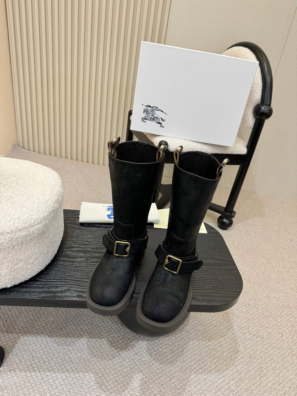 Black mid-calf boots with gold buckle straps, side view