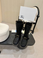 Black mid-calf boots with gold buckle straps, side view