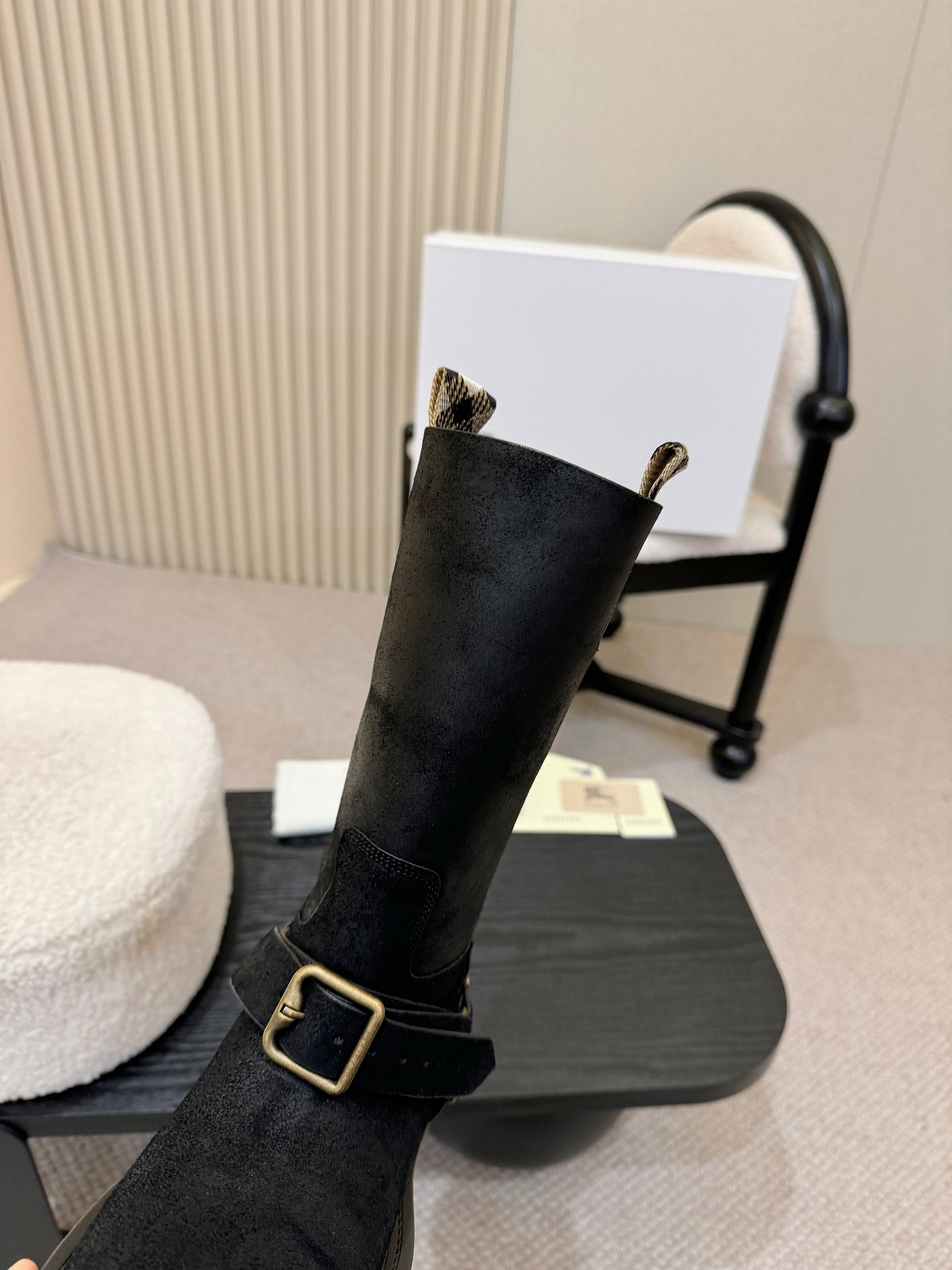 Black mid-calf boot with gold buckle strap, side close-up