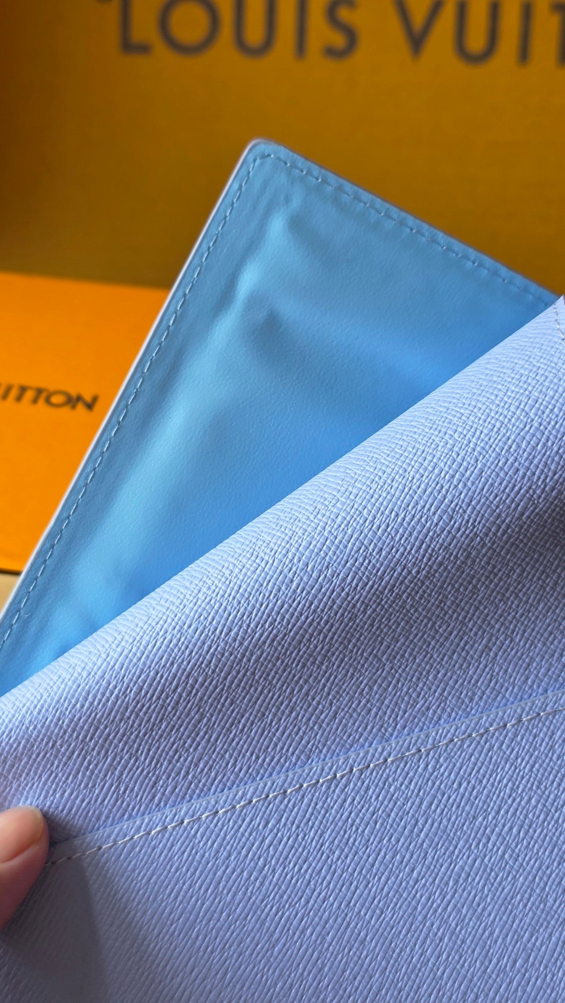 Light blue small pouch with textured finish and double-row stitching detail