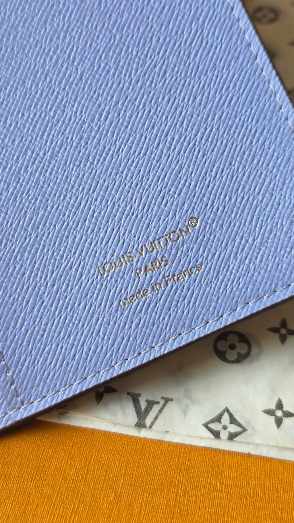 Light blue small pouch with embossed Louis Vuitton logo on corner