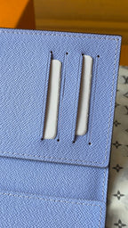 Light blue small pouch with two vertical metal slots on textured flap