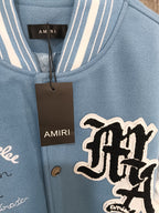 Light blue varsity jacket front with ribbed collar and large embroidered logo patch