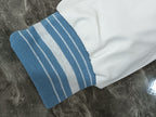 White and light blue striped ribbed cuff on the varsity jacket sleeve