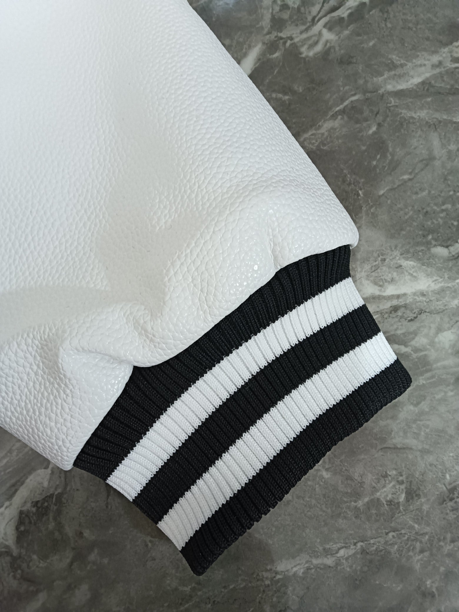 Givenchy varsity jacket sleeve: white textured finish with ribbed black-and-white cuff